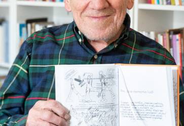 Miroslav Cipár ukazuje ilustráciu k novembru 1989 v knihe rozhovorov s Martinou Grochálovou Poèmáraný život. Snímka: Erika Litváková
